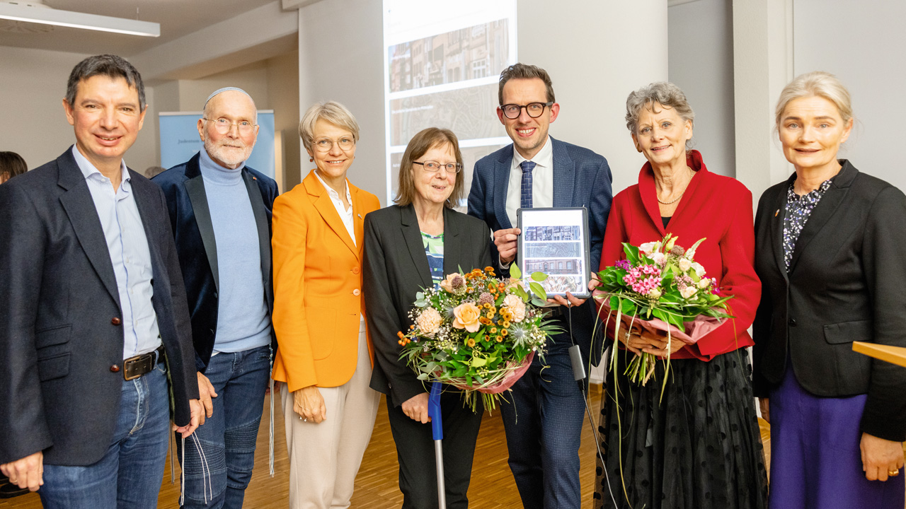 Gruppenfoto beim Festakt: Prof. Dr. Johannes Schnocks, Gesellschaft für Christlich-Jüdische Zusammenarbeit Münster; Sharon Fehr, Ehrenvorsitzender der Jüdischen Gemeinde Münster; Dorothee Feller, Ministerin für Schule und Bildung des Landes NRW; Prof. Dr. Marie-Theres Wacker, Vorstand des Vereins zur Förderung des Jüdischen Friedhofs an der Einsteinstr.; Dipl.-Theol. Ludger Hiepel M.A., Vorstand des Vereins zur Förderung des Jüdischen Friedhofs an der Einsteinstr.; Hiltrud Hadassah Geburek, Vorstand des Vereins zur Förderung des Jüdischen Friedhofs an der Einsteinstr.; Angela Stähler, Bürgermeisterin. Foto: © Peter Leßmann